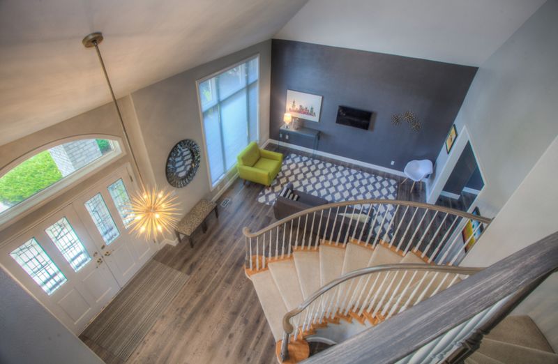 Entry hall seen from above with a curved staircase and living room, enhanced sample frame.